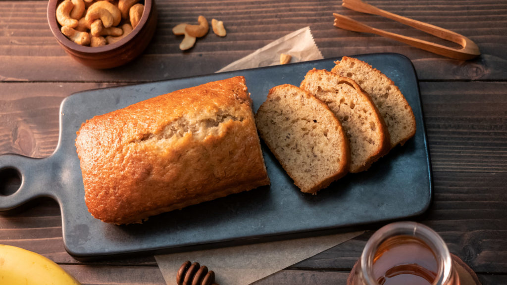 Homemade banana bread sliced with cashew nuts and honey